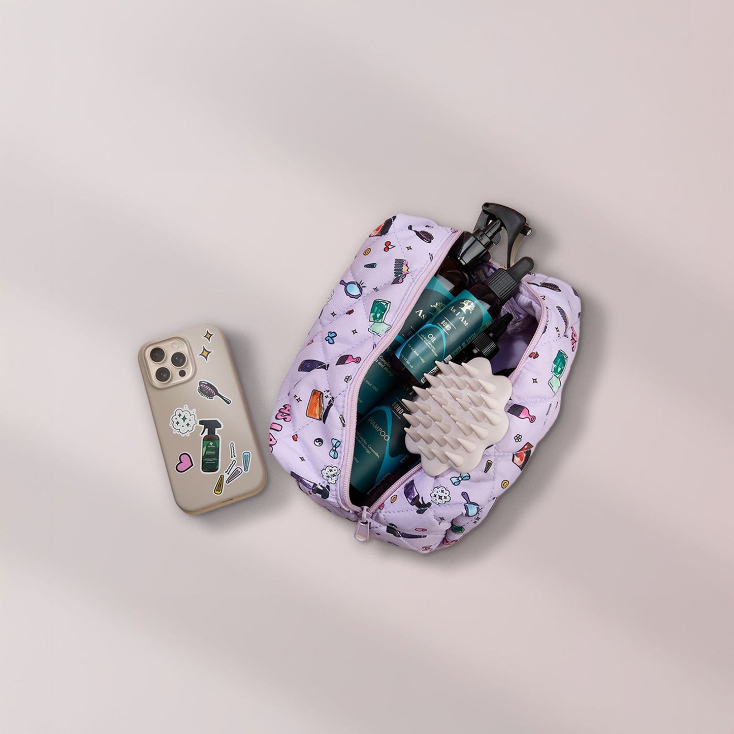 فرشاة فروة الرأس باللون البيج في حقيبة مستحضرات التجميل مع منتجات بوند وهاتف