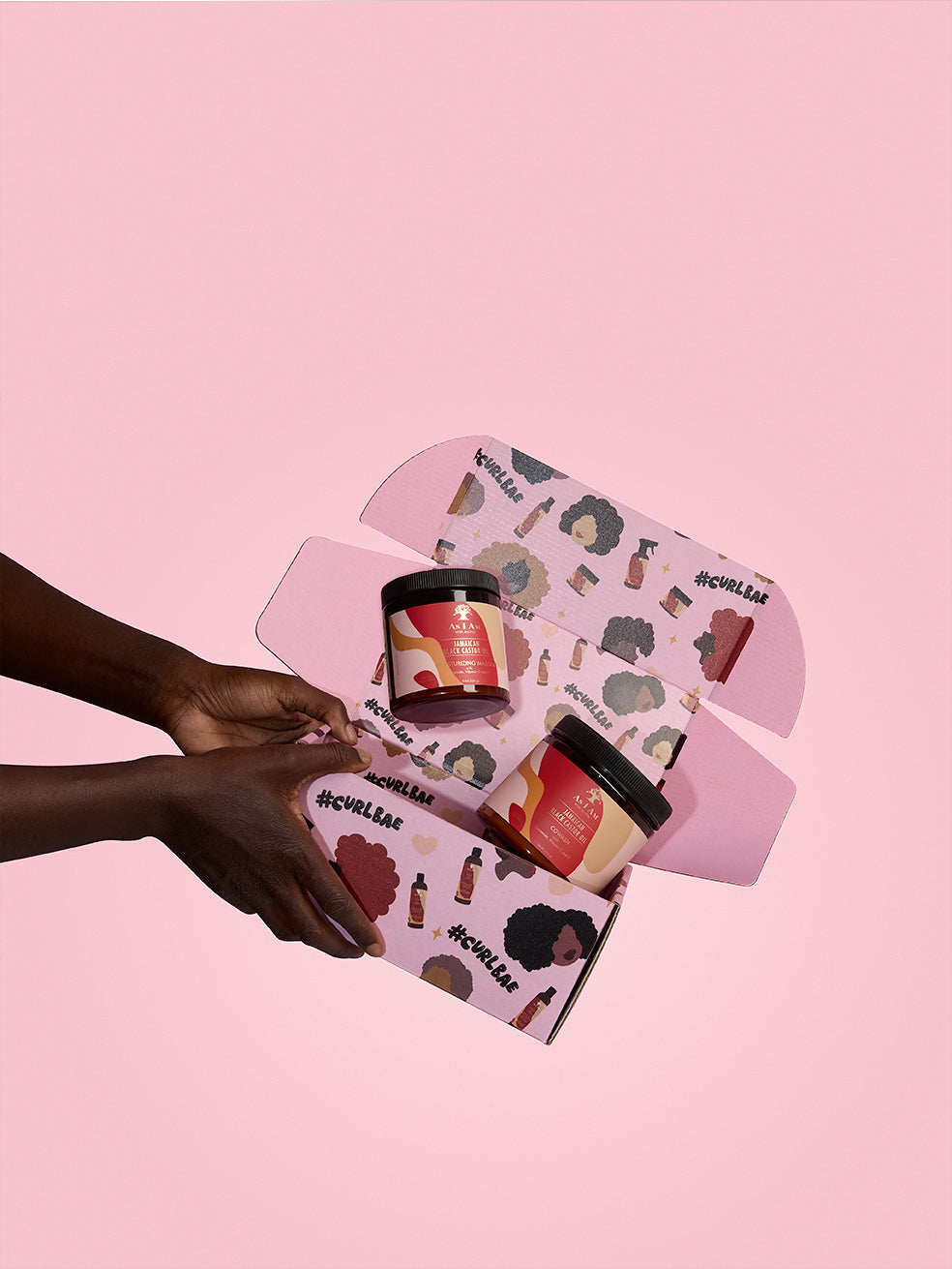 صندوق As I Am Curlbae Box الذي يحتوي على منتجات زيت الخروع الأسود الجامايكي - مجموعة العناية بالشعر المنتقاة بعناية تتضمن تركيبات مغذية مصممة لتقوية الشعر وترطيبه، وتحديد تجعيداته الطبيعية.