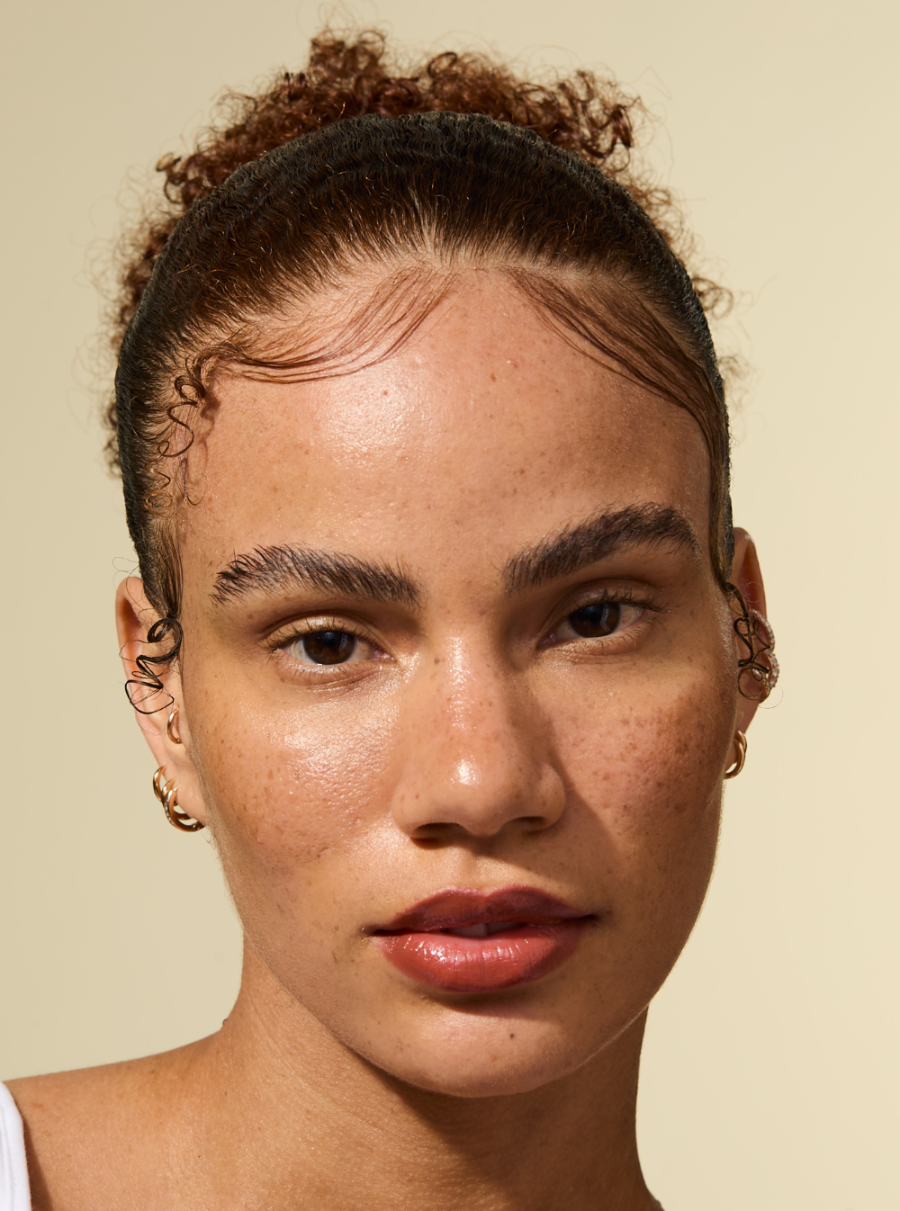 نموذج مع حواف أنيقة ومصفوفة وتسريحة شعر مصقولة مصففة باستخدام عصا الشمع AS I AM روزماري يبدو الشعر ناعمًا وخاليًا من التجعد ومثبتًا في مكانه بإحكام مع مظهر طبيعي.