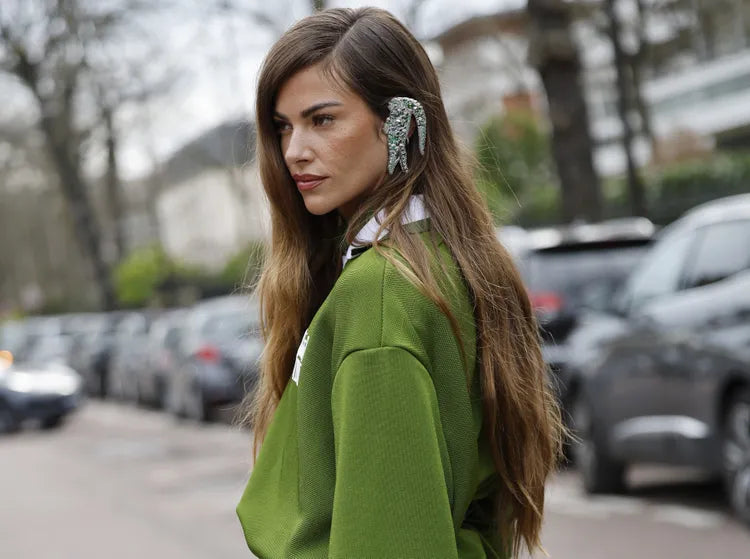 امرأة ترتدي ملابس خضراء مع خلفية ضبابية من السيارات والأشجار