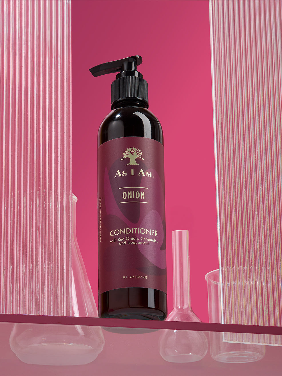زجاجة من بلسم "As I Am Onion" مع مضخة على خلفية وردية اللون