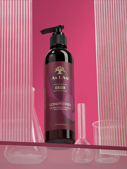 زجاجة من بلسم "As I Am Onion" مع مضخة على خلفية وردية اللون