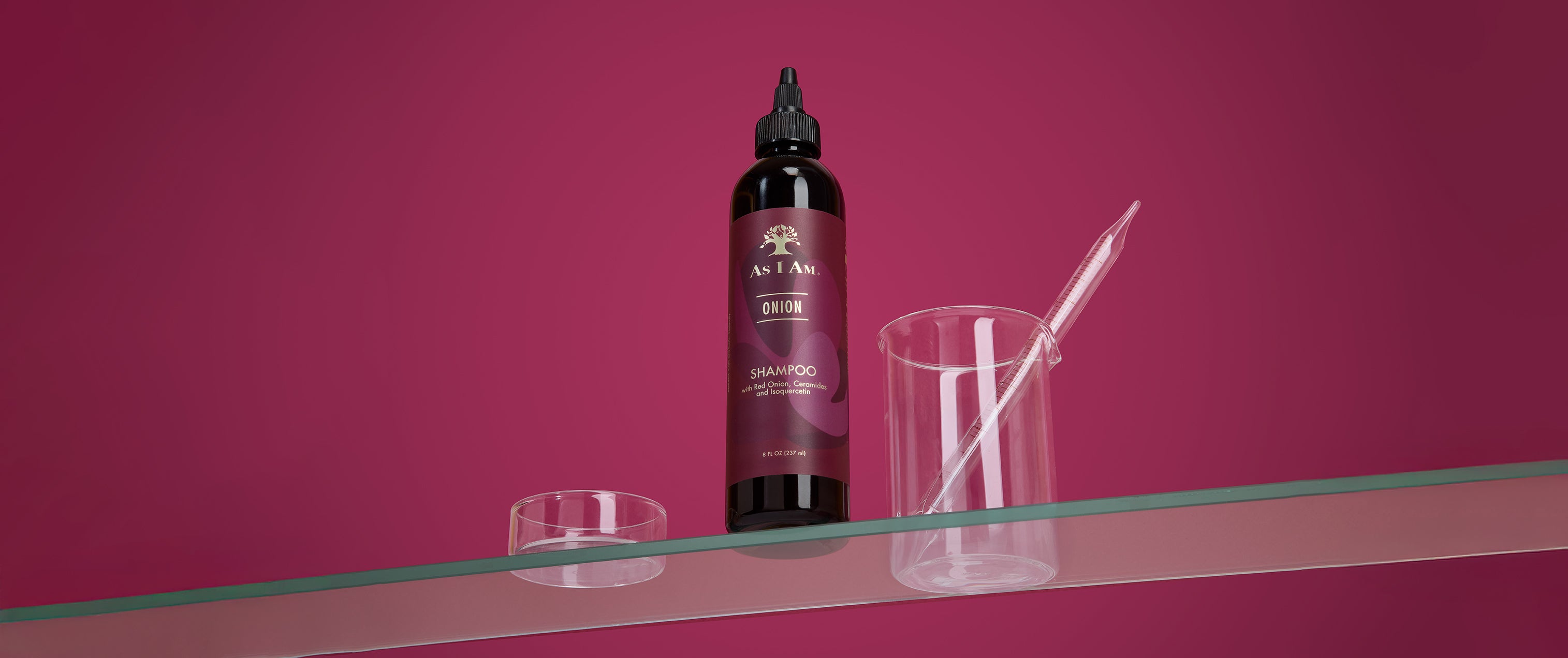 زجاجة شامبو للشعر مع فرشاة ووعاء شفاف على خلفية وردية