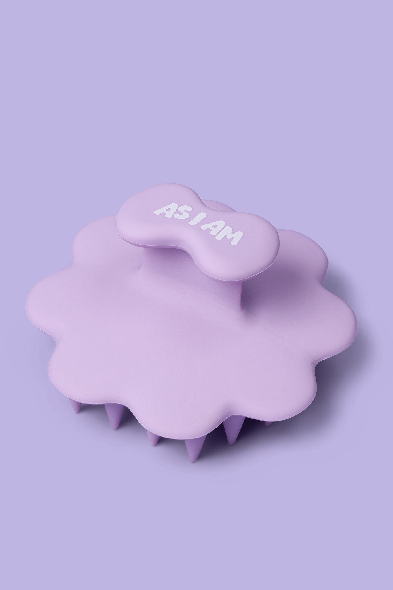 مدلك فروة الرأس باللون الأرجواني مع عبارة "AS I AM" على خلفية أرجوانية فاتحة